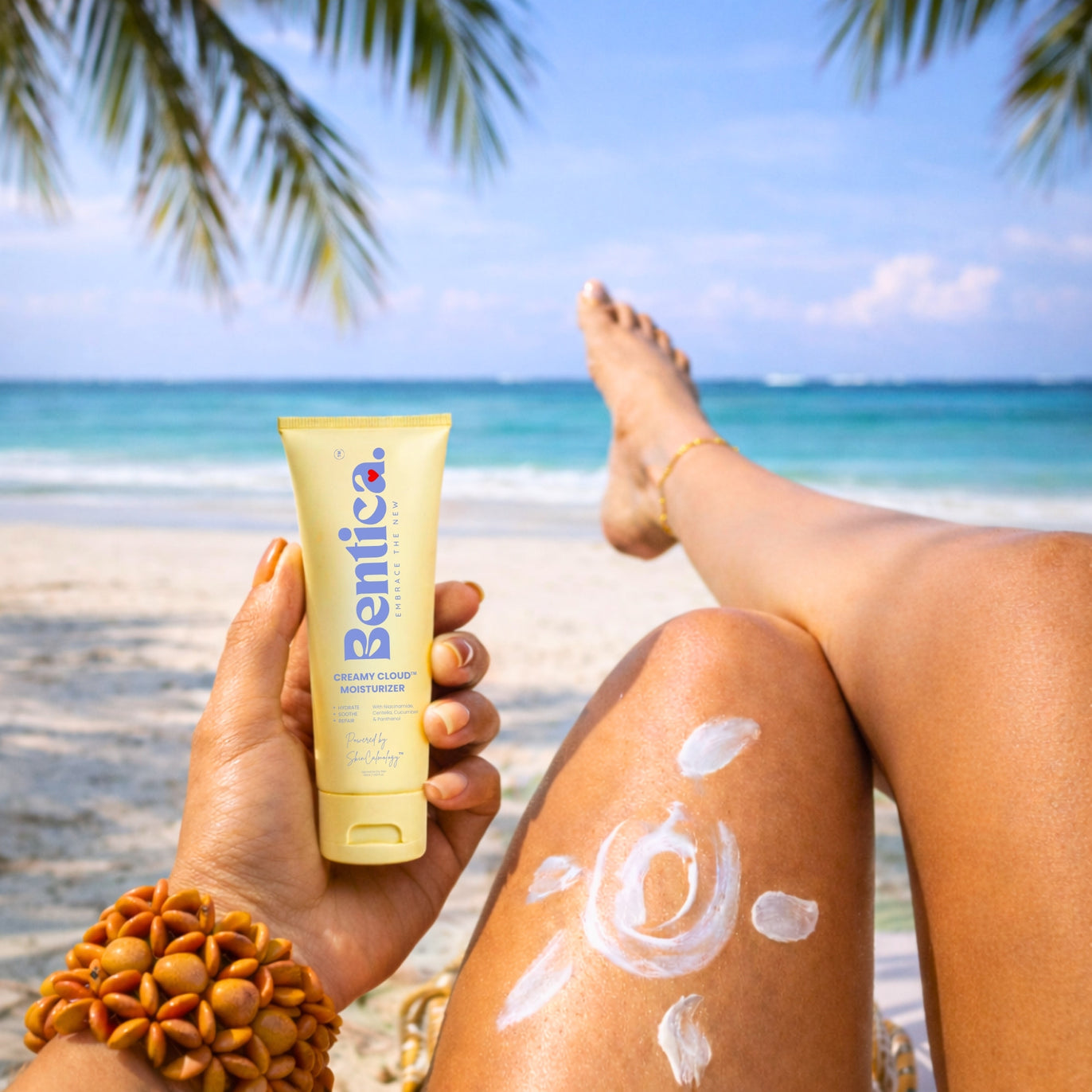 Person applying sunscreen on a beach with a Bentica moisturizer tube